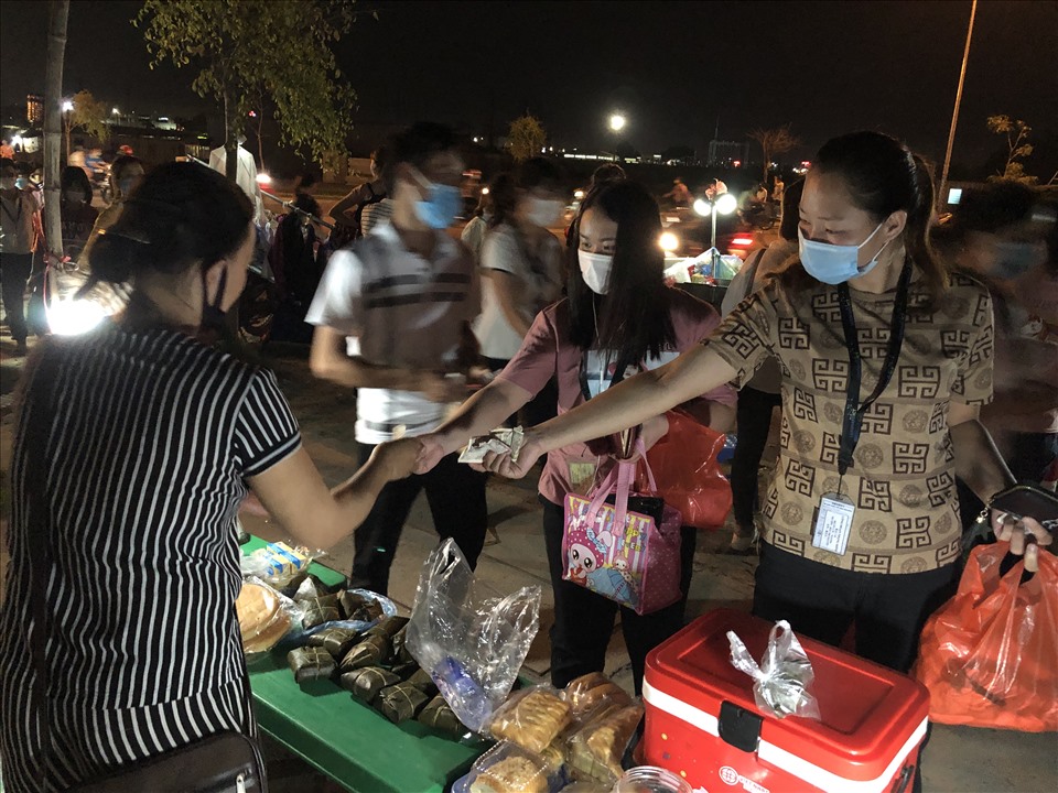 Công nhân Khu công nghiệp Vân Trung mua đồ ăn trước khi vào làm ca đêm. Ảnh minh hoạ. Ảnh: Bảo Hân.