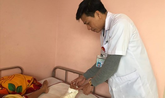 Bác sĩ Nguyễn Vũ Hoàng thăm khám chân cho bệnh nhi sau ca phẫu thuật. Ảnh: Khánh Chi