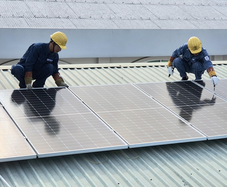 Các thanh niên công nhân thuộc EVNHCMC đang lắp đặt công trình điện mặt trời tại "Mái ấm Quận Tân Bình". Ảnh Nam Dương