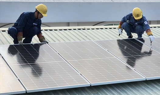 Các thanh niên công nhân thuộc EVNHCMC đang lắp đặt công trình điện mặt trời tại "Mái ấm Quận Tân Bình". Ảnh Nam Dương