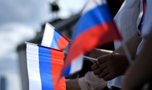Người dân cầm cờ Nga trong buổi lễ vào tháng 8.2020. Ảnh: AFP.