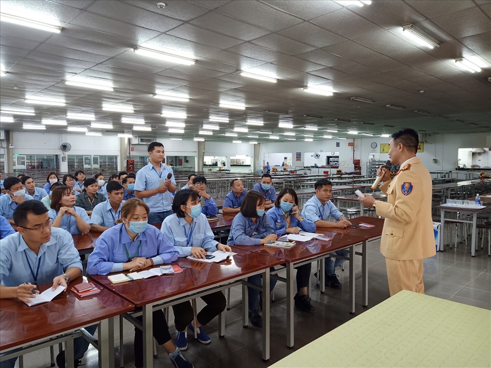 Cán bộ Cảnh sát giao thông tỉnh Hải Dương tuyên truyền Luật Giao thông tới người lao động. Ảnh: Diệu Thuý