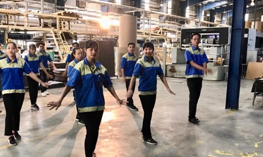 Người lao động Công ty CP MP Pack (ở TP.Đà Nẵng) đang tập thể dục giữa giờ nghỉ ca tại phân xưởng. Ảnh: Trà Giang