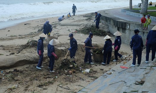Hàng chục công nhân khẩn trương dọn rác bãi biển Nha Trang sau 3 ngày mưa lũ kéo dài. Ảnh: Nhiệt Băng