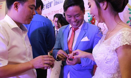 Cặp đôi công nhân hạnh phúc đeo nhẫn cho nhau trong đám cưới tập thể. Ảnh: Đình Trọng