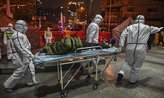 Nhân viên y tế mặc quần áo bảo hộ để ngăn chặn sự lây lan của virus khi đón một bệnh nhân ở Bệnh viện Chữ thập đỏ Vũ Hán ở Vũ Hán vào ngày 25.1.2020. Ảnh: AFP