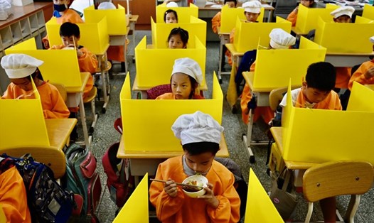 Học sinh ăn trưa trên bàn có vách ngăn bằng nhựa nhằm ngăn chặn lây lan COVID-19 tại trường tiểu học ở Đài Bắc, Đài Loan (Trung Quốc) hồi tháng 4. Ảnh: AFP.