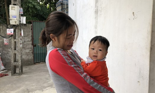 Một nữ công nhân tại khu công nghiệp Bắc Thăng Long (Hà Nội) và con nhỏ trước cửa phòng trọ. Ảnh: Bảo Hân.