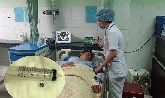 Người đàn ông bị đạn bắn trúng đang được điều trị ở Bệnh viện Đa khoa Vĩnh Đức. Ảnh: Thanh Chung