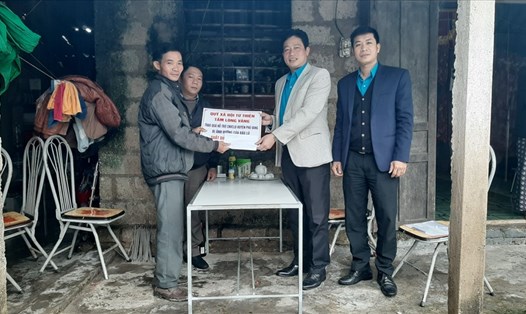 Ông Châu Đức Hoàng - Chủ tịch LĐLĐ huyện Phú Vang trao hỗ trợ cho các gia đình có người thân thiệt mạng do bão lũ. Ảnh: Đình Phô.