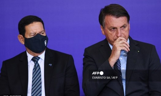 Phó Tổng thống Brazil Hamilton Mourão (đeo khẩu trang, bên trái) có kết quả dương tính với COVID-19 hôm 27.12. Ảnh: AFP