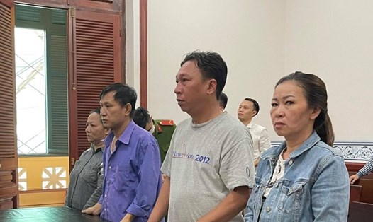 Cựu cán bộ công an Phạm Quang Tiến (áo xanh, thứ 3 phải sang) và các bị cáo khác tại phiên tòa. Ảnh: Tân Châu