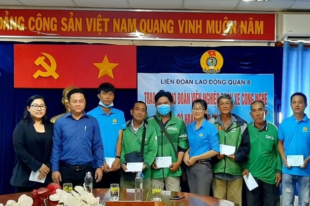 Các đoàn viên Nghiệp đoàn xe công nghệ Quận 8 có hoàn cảnh khó khăn được nhận quà do tổ chức Công đoàn Quận 8 trao tặng. Ảnh Đức Long