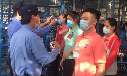 Toàn bộ người lao động của Công ty May mặc Triple Việt Nam được đo thân nhiệt trước khi vào công ty làm việc. Ảnh: Đức Long