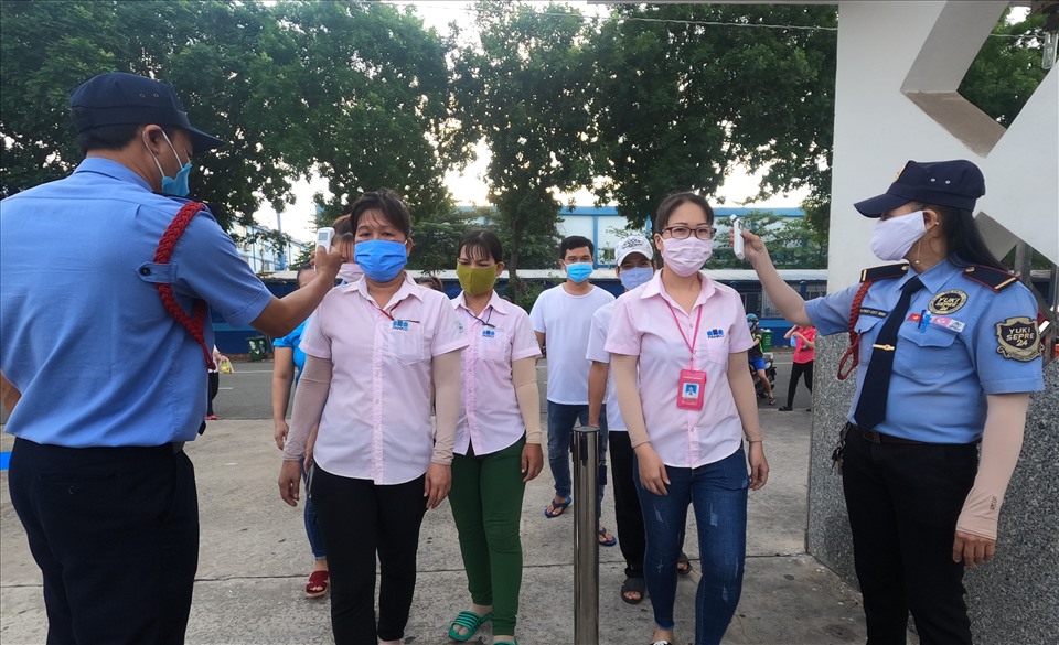 Nhiều công ty duy trì nghiêm ngặt việc đeo khẩu trang, đo thân nhiệt khi vào nhà máy. Ảnh: Đình Trọng
