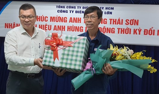 Tổng Giám đốc EVNHCMC Nguyễn Văn Thanh (bên trái) tặng hoa, chúc mừng ông Trương Thái Sơn. Ảnh: Nam Dương