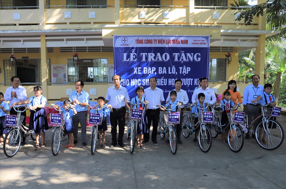 Đại diện CNVCLĐ ngành điện lực miền Nam trao tặng xe đạp cho các em học sinh vượt khó học giỏi của tỉnh Vĩnh Long. Ảnh EVNSPC cung cấp.