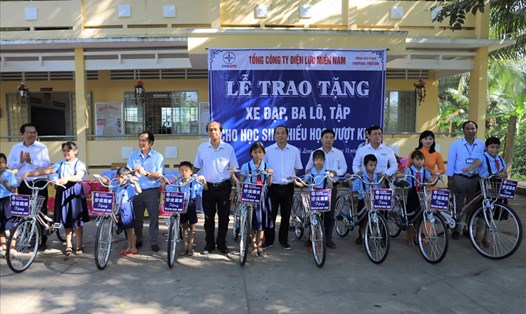 Đại diện CNVCLĐ ngành điện lực miền Nam trao tặng xe đạp cho các em học sinh vượt khó học giỏi của tỉnh Vĩnh Long. Ảnh EVNSPC cung cấp.