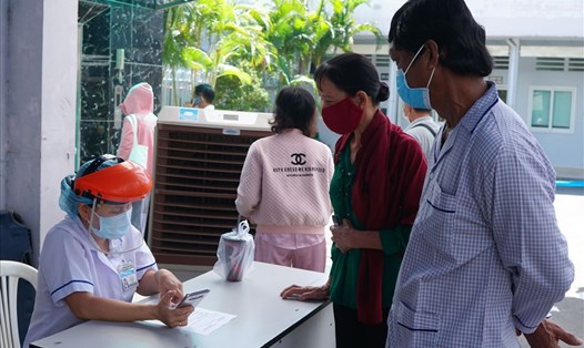 Người đến khám chữa bệnh tiến hành khai báo y tế tại bệnh viện Ung Bướu (quận Bình Thạnh, TPHCM). Ảnh: Thanh Chân