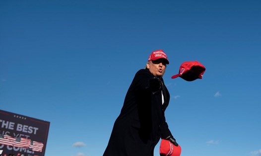 Tổng thống Mỹ Donald Trump tung mũ cho những người ủng hộ trong cuộc vận động tranh cử ở Avoca, Pennsylvania. Ảnh: AFP.