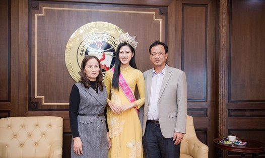 Hoa hậu Việt Nam Đỗ Thị Hà diện áo dài bên cạnh bố mẹ. Ảnh: SV