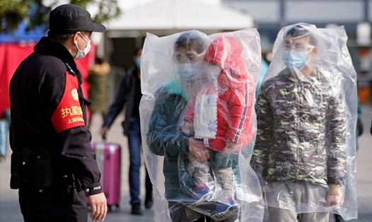 Hành khách tại nhà ga ở Thượng Hải đang tìm cách tự bảo vệ bằng túi nilon. Ảnh: Reuters.