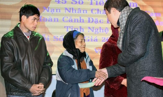 Ông Lê Văn Hồng trao sổ tiết kiệm cho gia đình các nạn nhân chất độc da cam. Ảnh: PV