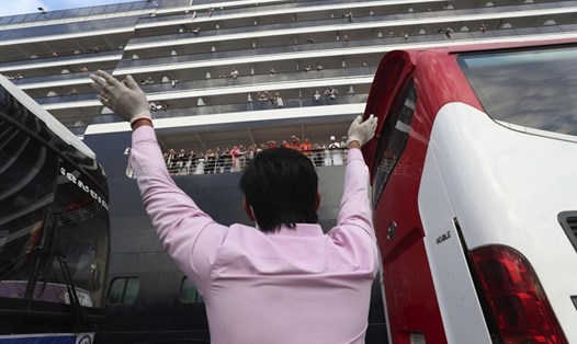 Một người đàn ông vẫy chào hành khách của MS Westerdam khi tàu cập cảng. Ảnh: ABP.