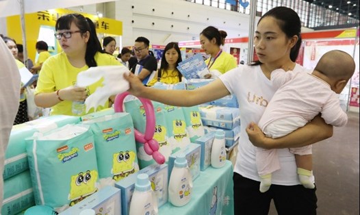 Một bà mẹ đang mua đồ cho trẻ sơ sinh ở Trung Quốc. Ảnh: China Daily