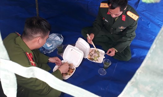 Lực lượng chức năng và bữa ăn vội tại xã Sơn Lôi (huyện Bình Xuyên, tỉnh Vĩnh Phúc). Ảnh Ái Vân