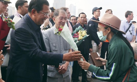 Một hành khách tàu Westerdam được Thủ tướng Hun Sen tặng hoa. Ảnh: ABP.