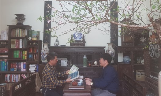 Ông Hoàng Tuấn Công (trái) trao đổi với nhà báo Xuân Hùng về cuốn "Từ điển thành ngữ tục ngữ Việt Nam".