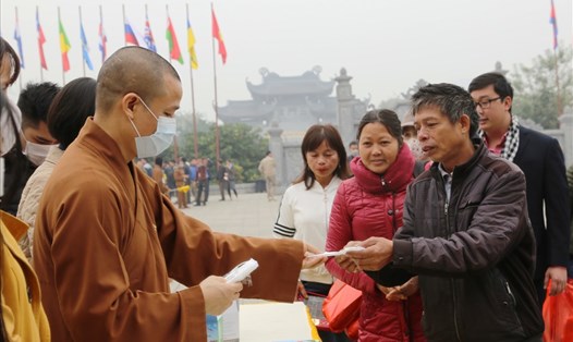 Thượng tọa Thích Minh Quang, Phó Trụ trì Thường trực chùa Bái Đính và các nhân viên phát khẩu trang cho du khách. Ảnh: NT