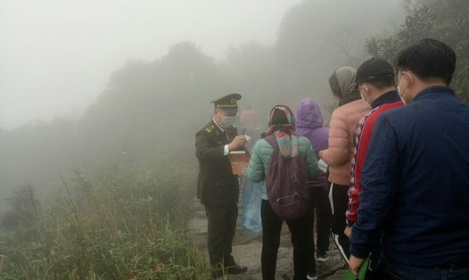 Các nhân viên Ban quản lý Di tích và rừng quốc gia Yên Tử phát khẩu trang miễn phí cho du khách hành hương về Yên Tử. Ảnh: CTV