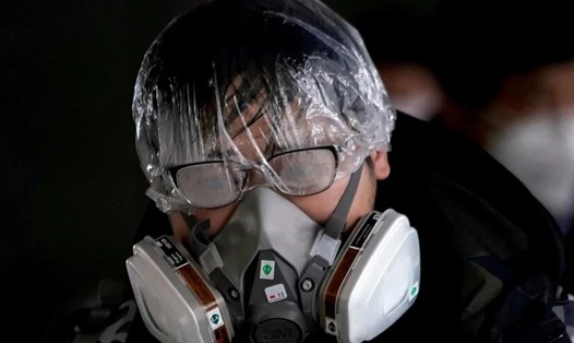Một người đeo khẩu trang và đồ bảo hộ phòng chống COVID-19. Ảnh: Reuters
