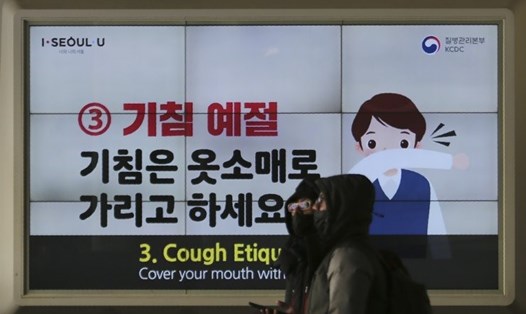 Người dân đi qua một biển cảnh báo phòng ngừa dịch COVID-19 ở Seoul, Hàn Quốc. Ảnh: AP.
