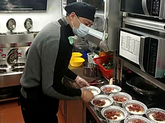 Ông Liu Xiaohu đang chuẩn bị đồ ăn cho các bác sĩ điều trị COVID-19. Ảnh: China Daily