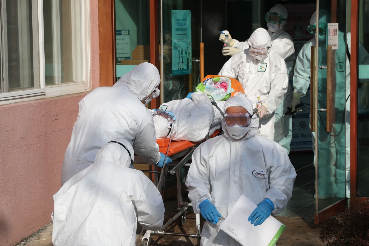 Nhân viên y tế chuyển một bệnh nhân nghi nhiễm COVID-19 khỏi bệnh viện Daenam, thành phố Cheongdo. Ảnh: Yonhap