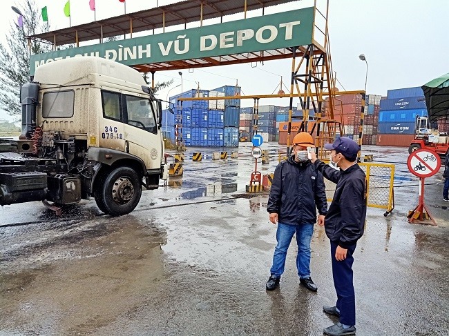 Người lao động được đo thân nhiệt trước khi vào kho tại Công ty cổ phần Đầu tư Xây dựng và Thương mại MOTACHI. Ảnh: N.P