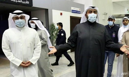 Bộ trưởng Y tế Kuwait Sheikh Basel al-Sabah (bên phải) phát biểu trước báo chí tại sân bay Sheikh Saad ngày 23.2, trong khi những người Kuwait trở về từ Iran chờ xét nghiệm COVID-19. Ảnh: AFP