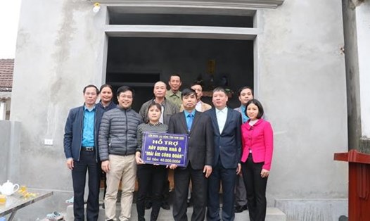 Đồng chí Trần Trọng Thái - Phó chủ tịch Thường trực LĐLĐ tỉnh cùng đoàn đại biểu và chị Đoàn Thị Vui bên ngôi nhà mới của chị.
