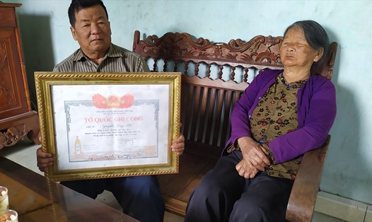 Ông Nguyễn Duy Phổ cầm bằng "Tổ quốc ghi công" ghi tên mình bên mẹ già. Ảnh: Trần Lộc
