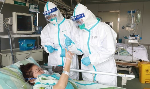 Nhân viên y tế đang trao đổi với một bệnh nhân nhiễm COVID-19 đang hồi phục tại Bệnh viện Trung Nam của Đại học Vũ Hán. Ảnh: China Daily