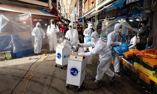Công nhân phun thuốc khử trùng phòng dịch tại chợ truyền thống Saemaeul ở Seoul, Hàn Quốc. Ảnh: EPA.