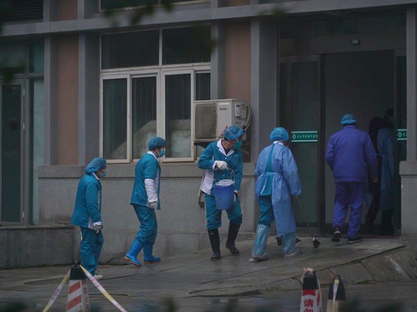 Nhân viên bệnh viện tại lối vào một trung tâm điều trị bệnh nhân nhiễm COVID-19 ở Vũ Hán, Trung Quốc. Ảnh: AP.