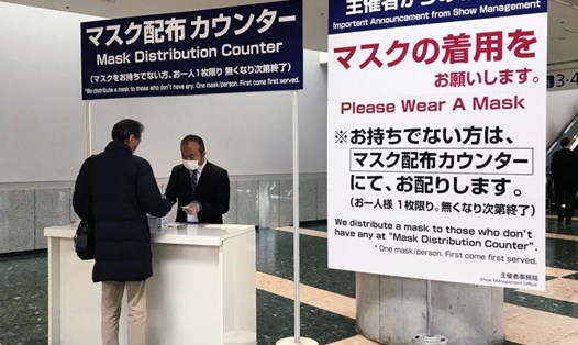 Một người đàn ông nhận khẩu trang trong bối cảnh dịch COVID-19 tại hội nghị Tuần lễ năng lượng thông minh 2020 ở Nhật Bản. Ảnh: Reuters