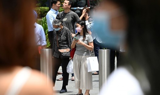 Người đi bộ đeo khẩu trang tại Singapore hôm 26.2. Ảnh: AFP.
