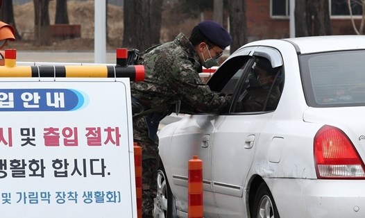 Một binh sĩ Hàn Quốc kiểm tra nhiệt độ ở cổng một căn cứ không quân ở Gyeryongdae, thành phố Gyeryong, tỉnh Chungcheong Nam. Ảnh: Yonhap.