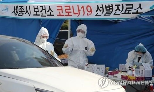 Các nhân viên y tế lấy mẫu xét nghiệm bằng quy trình "drive-thru" tại thành phố hành chính Sejong hôm 26.2. Ảnh: Yonhap.