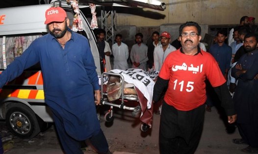 Thi thể nạn nhân được đưa tới bệnh viện sau vụ tai nạn nghiêm trọng giữa tàu hoả và xe buýt ở Pakistan. Ảnh: EPA
